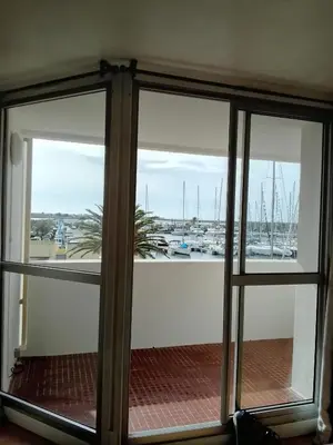 a view of a marina from a glass door at Appartement 6 personnes Gruissan in Gruissan