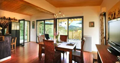 a dining room with a wooden table and chairs at Maison - piscine - Vue vignobles coeur de nature in Roquetaillade