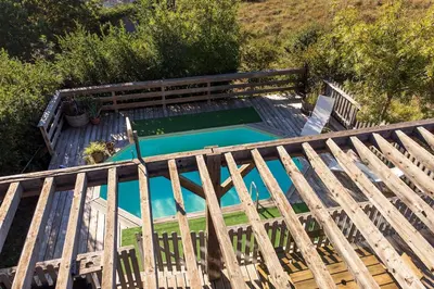 an overhead view of a wooden deck with a swimming pool at Lodge milieu - Piscine privée Terrasse - in Roquetaillade