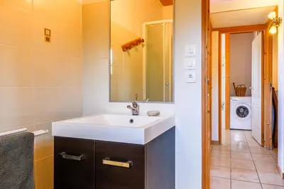 a bathroom with a sink and a washing machine at Lodge milieu - Piscine privée Terrasse - in Roquetaillade