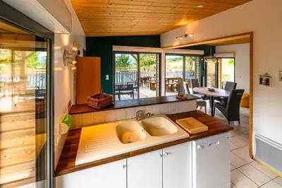 a kitchen with a counter with a sink and a table at Lodge milieu - Piscine privée Terrasse - in Roquetaillade