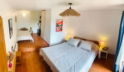 a bedroom with a bed and two tables with lamps at L'Amandière in Cucugnan