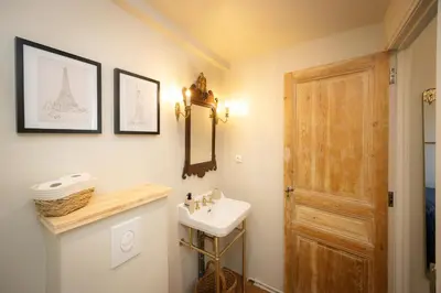a bathroom with a sink and a mirror and a door at Maison du canal du midi in Carcassonne