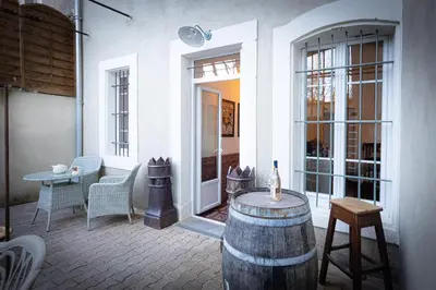 a patio with a wine barrel and a table and chairs at Maison du canal du midi in Carcassonne