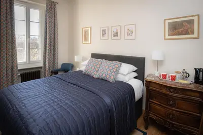 a bedroom with a bed with a blue blanket and a dresser at Maison du canal du midi in Carcassonne