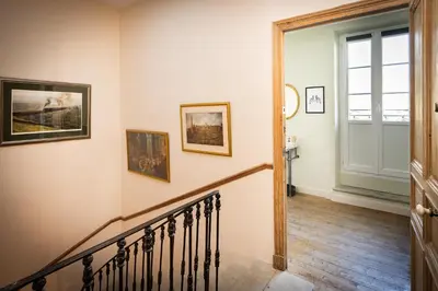 a hallway with a staircase with paintings on the wall at Maison du canal du midi in Carcassonne