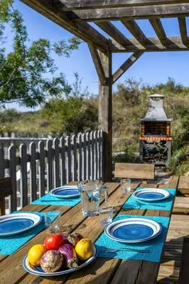 a wooden table with plates of food on it at Ecolodge - Calme - Piscine privée - vue nature in Roquetaillade