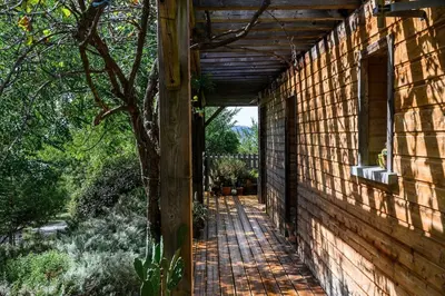 a wooden walkway leading to the side of a building at Ecolodge - Calme - Piscine privée - vue nature in Roquetaillade