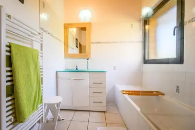 a bathroom with a tub and a sink and a mirror at Ecolodge - Calme - Piscine privée - vue nature in Roquetaillade
