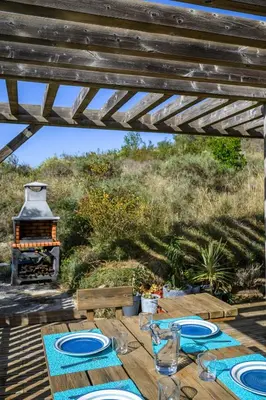a wooden table with plates on it with a fireplace at Ecolodge - Calme - Piscine privée - vue nature in Roquetaillade