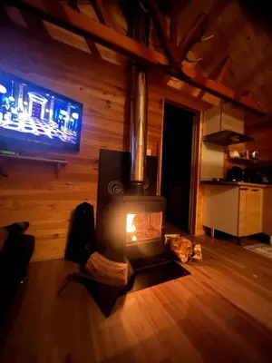 a living room with a woodburning stove in a cabin at Chalet Echo des Montagnes in Camurac