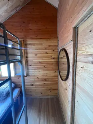 a room in a cabin with a bunk bed and a mirror at Chalet Echo des Montagnes in Camurac