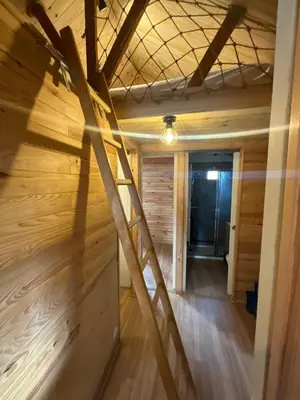 a room with a wooden wall and a wooden floor at Chalet Echo des Montagnes in Camurac