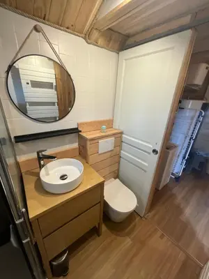 a bathroom with a sink and a toilet and a mirror at Chalet Echo des Montagnes in Camurac