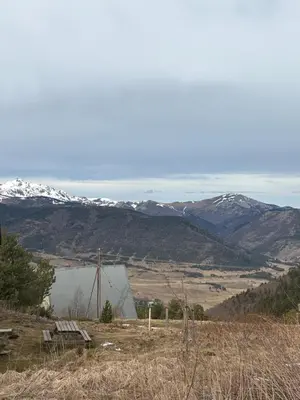a barn on a hill with snow covered mountains at Chalet Echo des Montagnes in Camurac