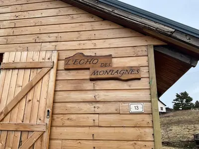 a sign on the side of a wooden building at Chalet Echo des Montagnes in Camurac