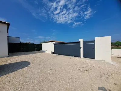 a white building with two garage doors on it at Villa d'artistes in Malras