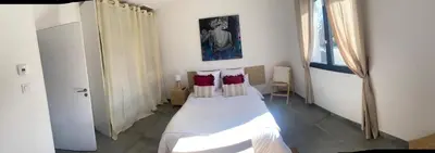 a bedroom with a bed with two red pillows at Villa d'artistes in Malras