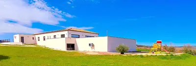 a white building on a hill with a green field at Villa d'artistes in Malras