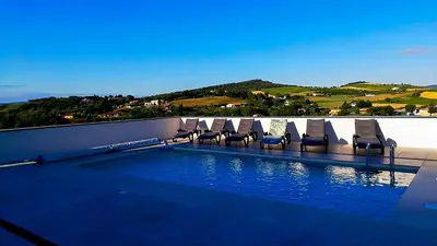 a swimming pool with lounge chairs on a balcony at Villa d'artistes in Malras