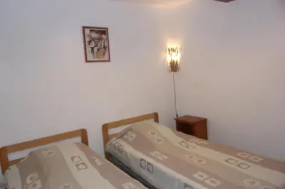 a bedroom with two beds and a light on the wall at DOMAINE LE PLA de LIÉRE in Maury