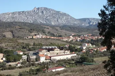 a town in the mountains with a mountain in the background at DOMAINE LE PLA de LIÉRE in Maury