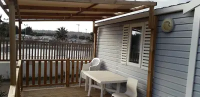 a patio with a table and chairs on a deck at omer port la nouvelle in Port-la-Nouvelle