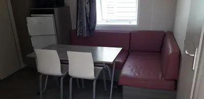 a kitchen with a dining table and a couch at omer port la nouvelle in Port-la-Nouvelle