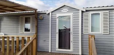 a tiny house with a door on a deck at omer port la nouvelle in Port-la-Nouvelle