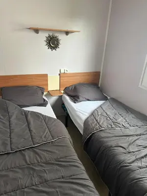 two beds are in a room with at MOBIL HOME Le Soleil,3CH,6PERS in Port-la-Nouvelle