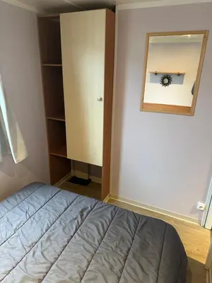 a bedroom with a bed and a mirror at MOBIL HOME Le Soleil,3CH,6PERS in Port-la-Nouvelle