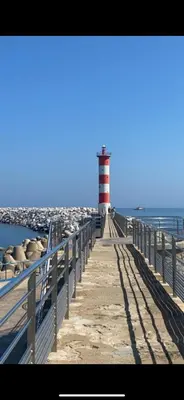 a red and white lighthouse on a pier next to the water at MOBIL HOME Le Soleil,3CH,6PERS in Port-la-Nouvelle