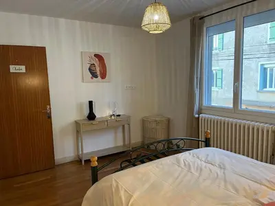 a bedroom with a bed and a window and a table at Maison de Village in Lacrouzette