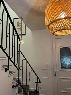a hallway with a staircase with a chandelier at Maison de Village in Lacrouzette