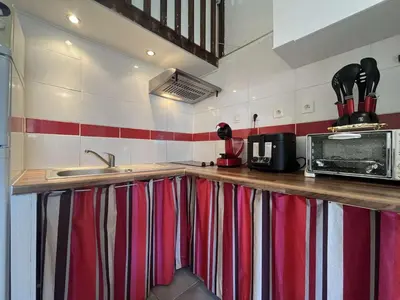 a kitchen with red and white stripes on the wall at Pavillon confort avec parking et piscine collective - GN180-057 in Gruissan