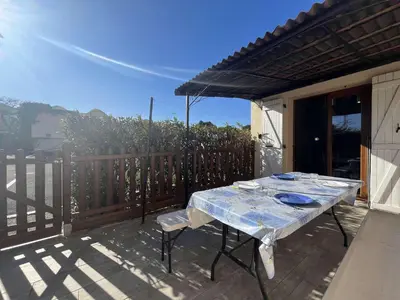 a table sitting on a deck with a fence at Pavillon confort avec parking et piscine collective - GN180-057 in Gruissan