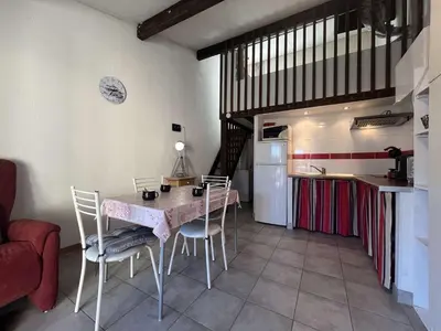 a kitchen with a table and chairs in a room at Pavillon confort avec parking et piscine collective - GN180-057 in Gruissan