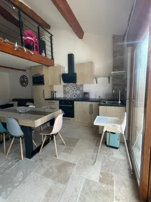 a kitchen with a table and chairs in a room at studio cosy a la ferme in Saint-Julia