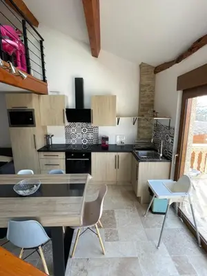 a kitchen with a table and chairs in a room at studio cosy a la ferme in Saint-Julia