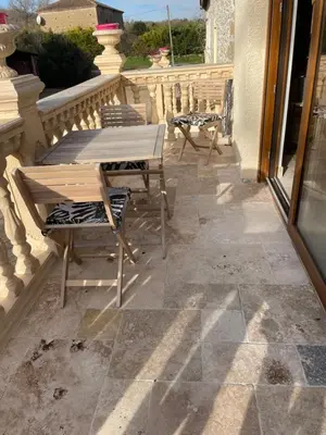 a patio with a table and chairs on a balcony at studio cosy a la ferme in Saint-Julia