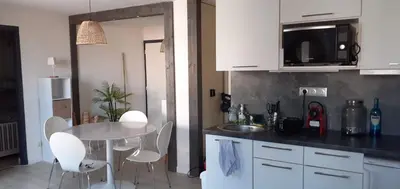 a kitchen with a white table and white chairs at L'Escapade Marine in Gruissan