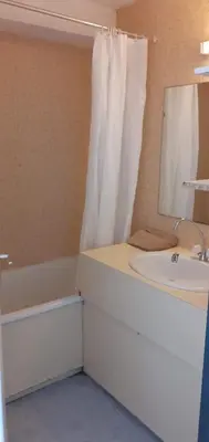 a bathroom with a sink and a tub and a mirror at L'Escapade Marine in Gruissan