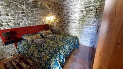 a bedroom with a bed in a stone wall at La Concha 1 in Conques-sur-Orbiel