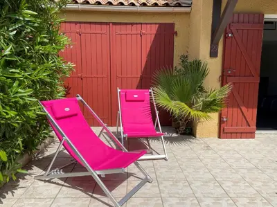 two pink chairs sitting in front of a house at Maison front de plage avec terrasse Grazel - GN210-027 in Gruissan