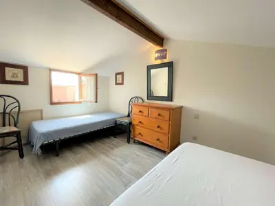 a bedroom with two beds and a dresser and a mirror at Maison front de plage avec terrasse Grazel - GN210-027 in Gruissan
