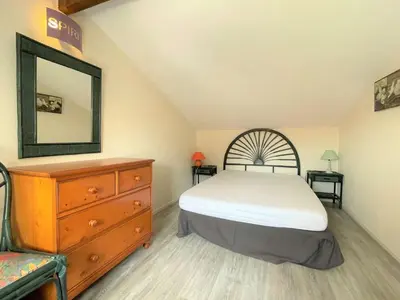 a bedroom with a bed and a dresser and a mirror at Maison front de plage avec terrasse Grazel - GN210-027 in Gruissan