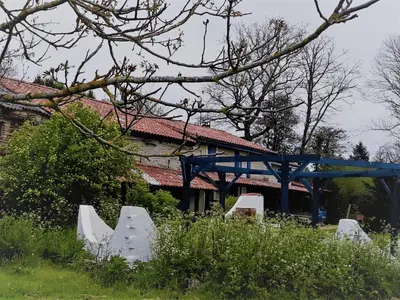 a sign in front of a building with a blue bridge at la source et la sorciere in Pradelles-Cabardès