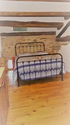 a bed in a room with a wooden floor at la source et la sorciere in Pradelles-Cabardès