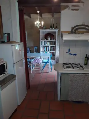 a kitchen with a white refrigerator and a table at la source et la sorciere in Pradelles-Cabardès