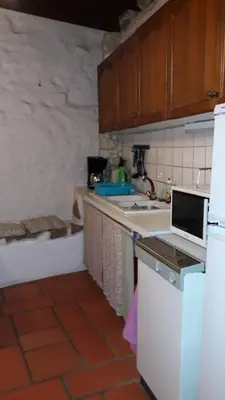 a kitchen with a white refrigerator and a sink at la source et la sorciere in Pradelles-Cabardès